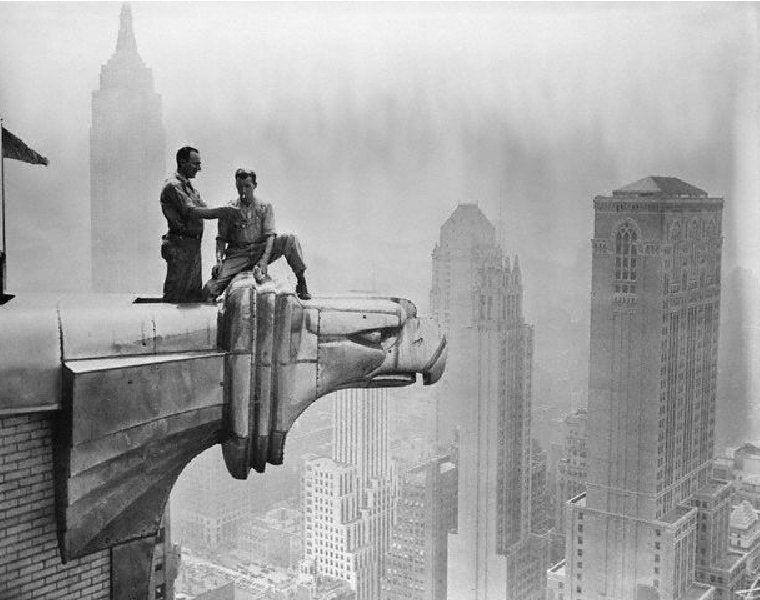 Archival image of workers standing on the gargoyle of the Chrysler Building in New York City